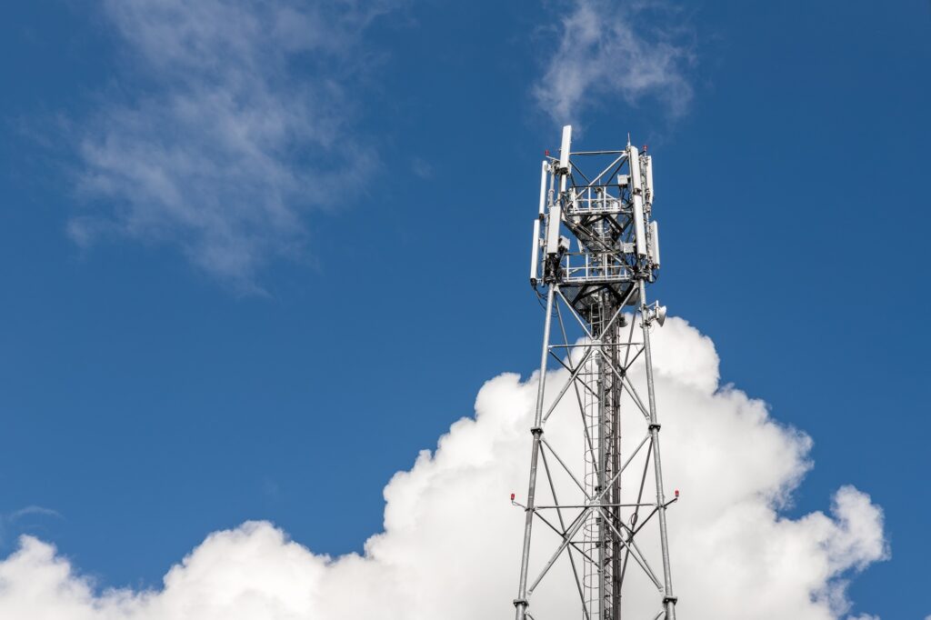 Bottom perspective pov of modern metal steel mobile 5g network wireless telecom tower against clear
