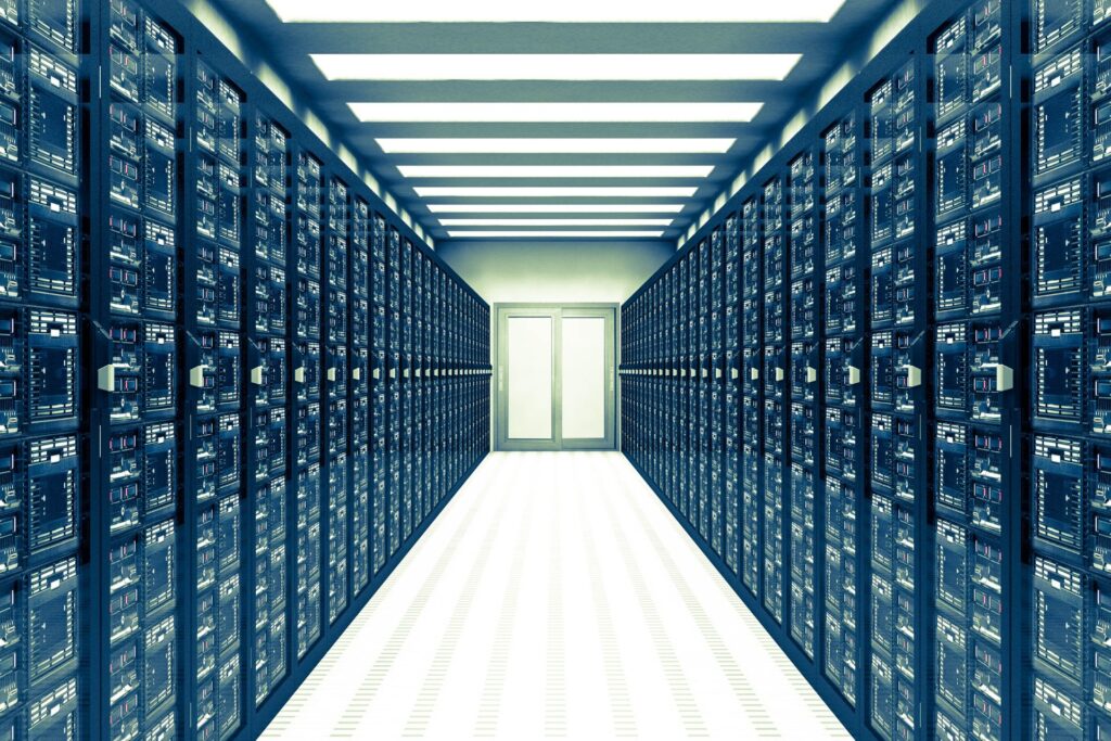 A brightly lit data center server room with rows of server racks lining both sides and a double door at the end of the aisle, supporting cloud operations.