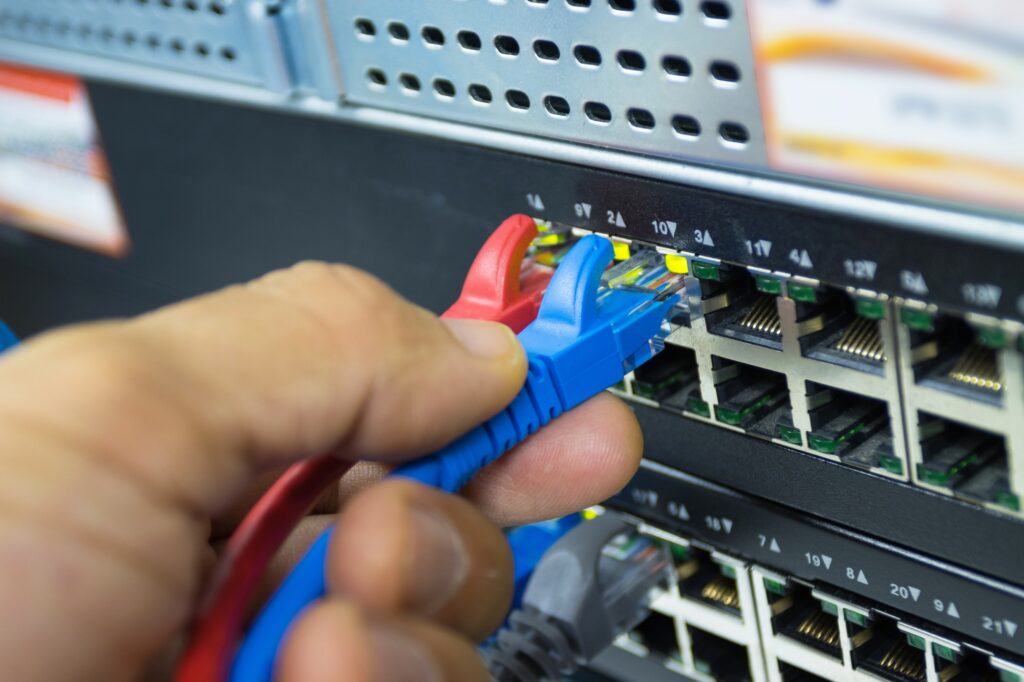 Hand of man holding The network cables to connect Lan port connect SFP module port in the Datacenter