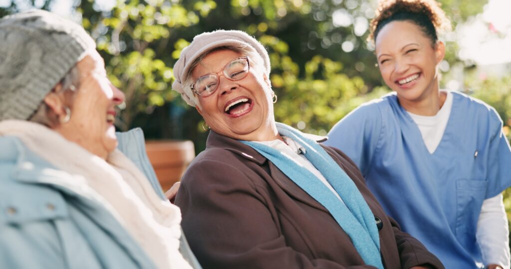 Nurse, senior women and laughing at park for funny conversation, community care and rehabilitation.