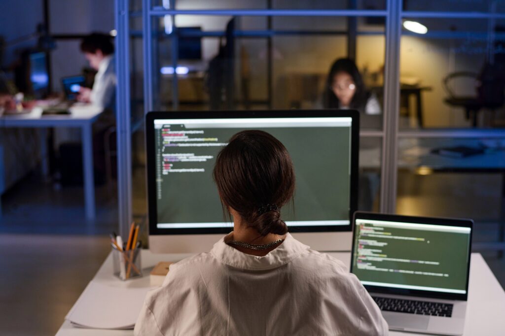 Young Programmer At Workplace In Evening